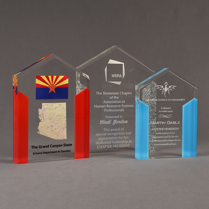 Three ColorCast™ acrylic pillars shaped trophies.